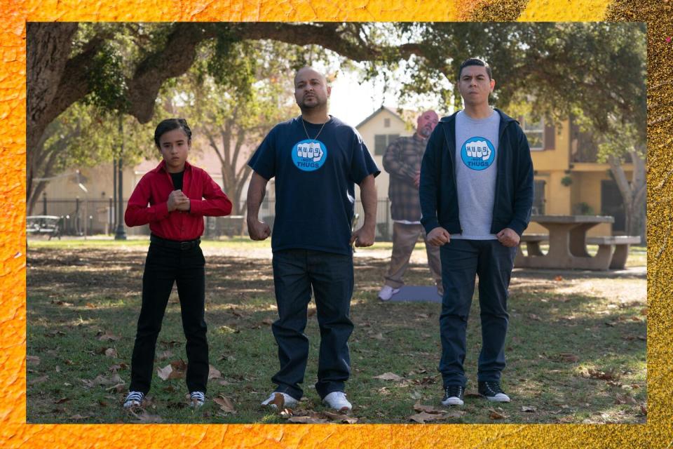 Two men and a young boy standing in a line, ready to fight