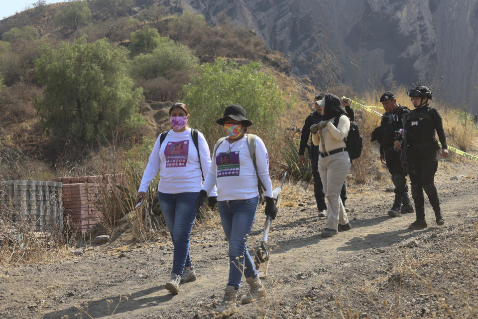 Women carry digging tools where they found a clandestine crematorium in Tlahuac, on the edge of Mexico City, Wednesday, May 1, 2024. Ceci Flores, a leader of one of the groups of so-called "searching mothers" from northern Mexico, announced late Tuesday that her team had found bones around clandestine burial pits and ID cards, and prosecutors said they were investigating to determine the nature of the remains found. (AP Photo/Ginnette Riquelme)