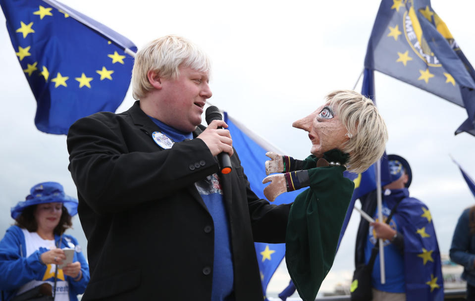 A Boris Johnson impersonator holds a Theresa May puppet during an Exit for Brexit rally during the second day of the Liberal Democrats Autumn Conference at the Bournemouth International Centre.