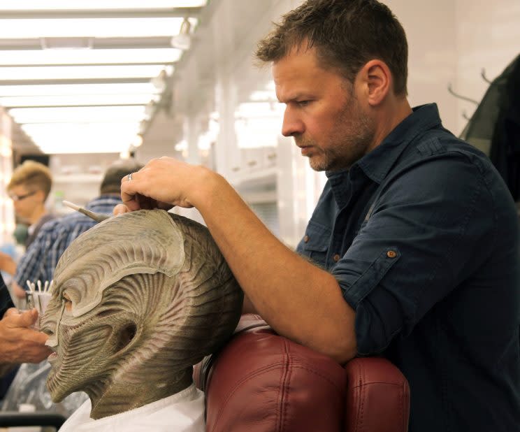 Harlow adjusts the headpiece on actor Joe Taslim (Manas). (Photo: Joel Harlow/Paramount Pictures)