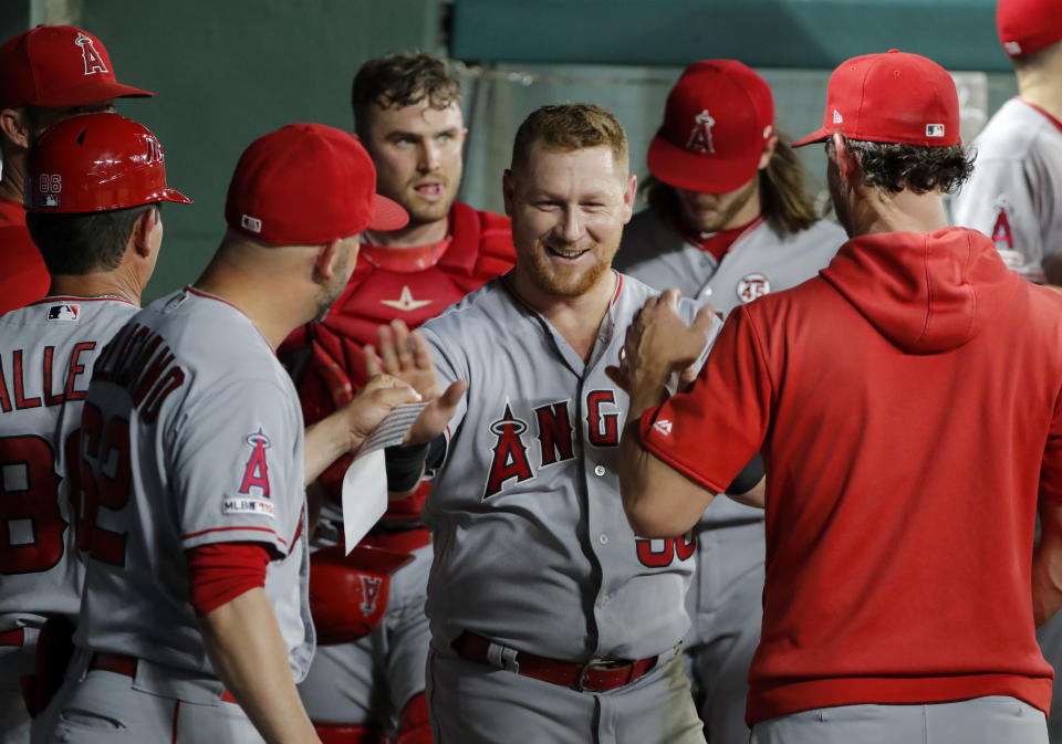 Los Angeles Angels' Kole Calhoun, center, is congratulated in the dugout after making an over-the-shoulder catch on a Texas Rangers' Elvis Andrus flyout to end to bottom of the fourth inning of baseball game in Arlington, Texas, Monday, Aug. 19, 2019. (AP Photo/Tony Gutierrez)