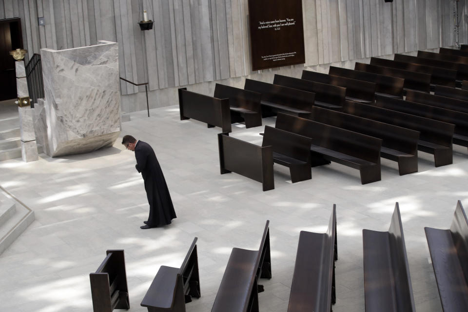 Father Glenn Baaten, chaplain of the Santiago Retreat Center in Silverado, Calif., bows next to the altar inside of the newly renovated Christ Cathedral Monday, July 8, 2019, in Garden Grove, Calif. The 88,000-square-foot Catholic church has undergone a $77 million renovation. (AP Photo/Marcio Jose Sanchez)