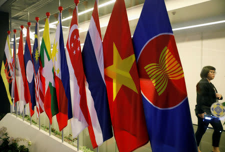 A woman passes ASEAN Summit flags at Suntec Convention Centre in Singapore, November 11, 2018. REUTERS/Edgar Su