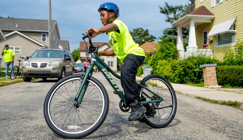 Da'Shawn Bratchett, 9, sports his new bike around the block following Andre Lee Ellis' birthday party and bike giveaway on Saturday at 1313 W. Reservoir Ave. "This is really cool. This bike is pretty fast," Bratchett said. The first bike Bratchett received got stolen. That is why they came today, his dad explained.