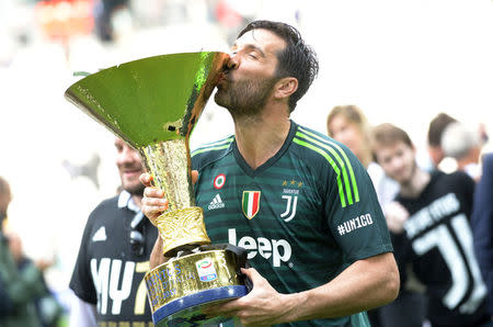 FILE PHOTO: Soccer Football - Serie A - Juventus vs Hellas Verona - Allianz Stadium, Turin, Italy - May 19, 2018 Juventus' Gianluigi Buffon celebrates winning the league by kissing the trophy REUTERS/Massimo Pinca/File Photo