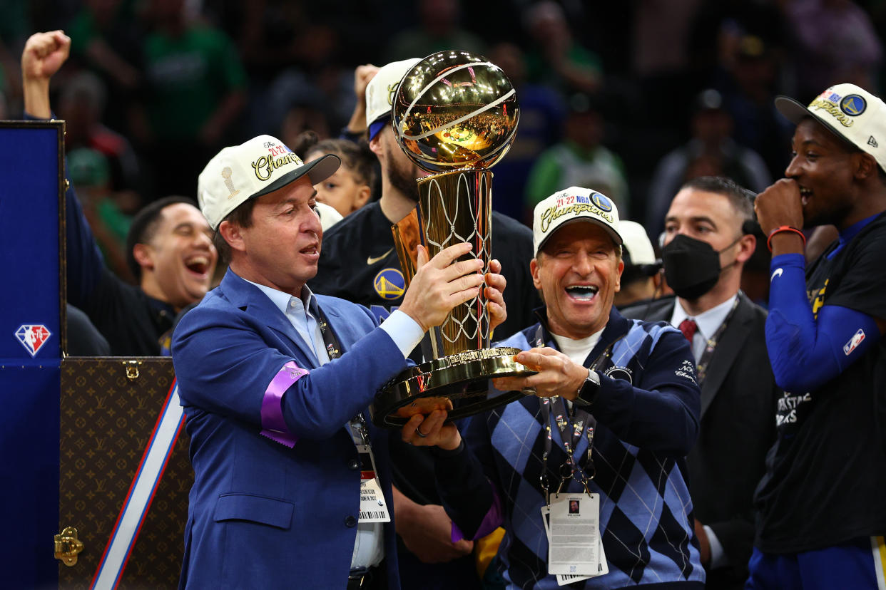 Golden State Warriors owners Joe Lacob and Peter Guber were presented the Larry O'Brien trophy when the team's players won the 2022 NBA Finals. (Elsa/Getty Images)