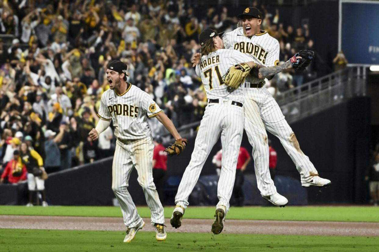 San Diego's Manny Machado, right, celebrates with relief pitcher Josh Hader and Wil Myers.