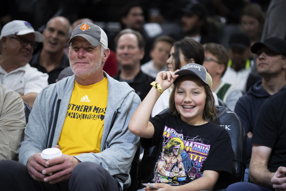 Former Green Bay Packers quarterback Brett Farve sits with his grandson Parker Valkenburg during the first quarter of an NBA basketball game between the Milwaukee Bucks and the Sacramento Kings in Sacramento, Calif., Wednesday, March 16, 2022. (AP Photo/José Luis Villegas)