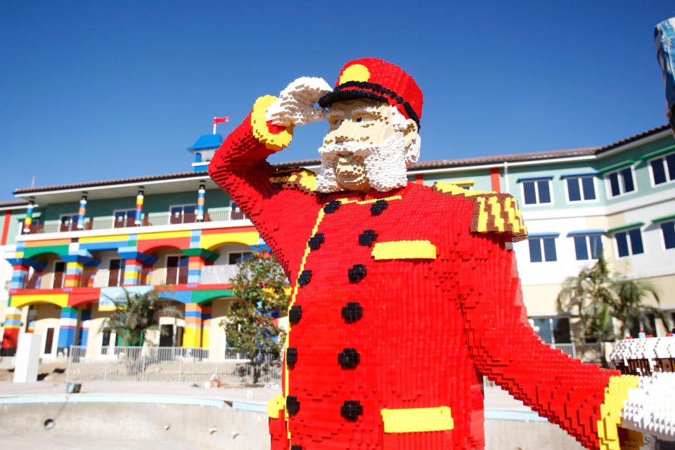 This undated publicity image released Legoland California Resort shows a Bellhop made of Legos greeting guests in front of Legoland Hotel at Legoland California Resort kin Carlsbad, Calif. Legoland also has a Carlsbad, California outpost and in April, opened a 250-room hotel. Visitors are greeted by a fire-breathing dragon made of 400,000 Lego bricks. Guest rooms are decorated in pirate, adventure or kingdom themes, and most items in the room appear as if they are built of Legos. (AP Photo/Legoland California Resort via PRNewswire)