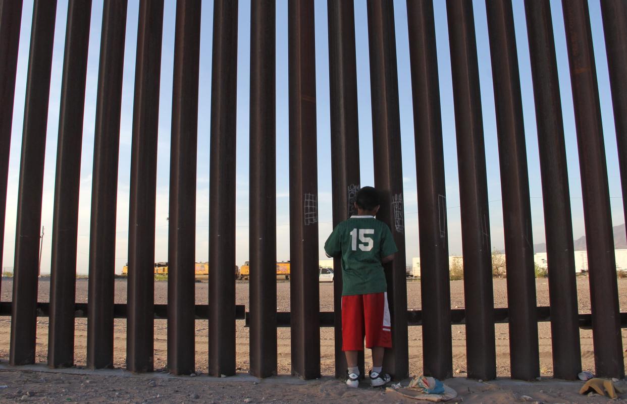 A Mexican child looks at a vehicle of the US border patrol through the US-Mexico fence in Ciudad Juarez, Chihuahua state, Mexico on 4 April, 2018. Human rights organisations have urged the US government to stop deporting Mexican children in rapid removals.  (AFP via Getty Images)