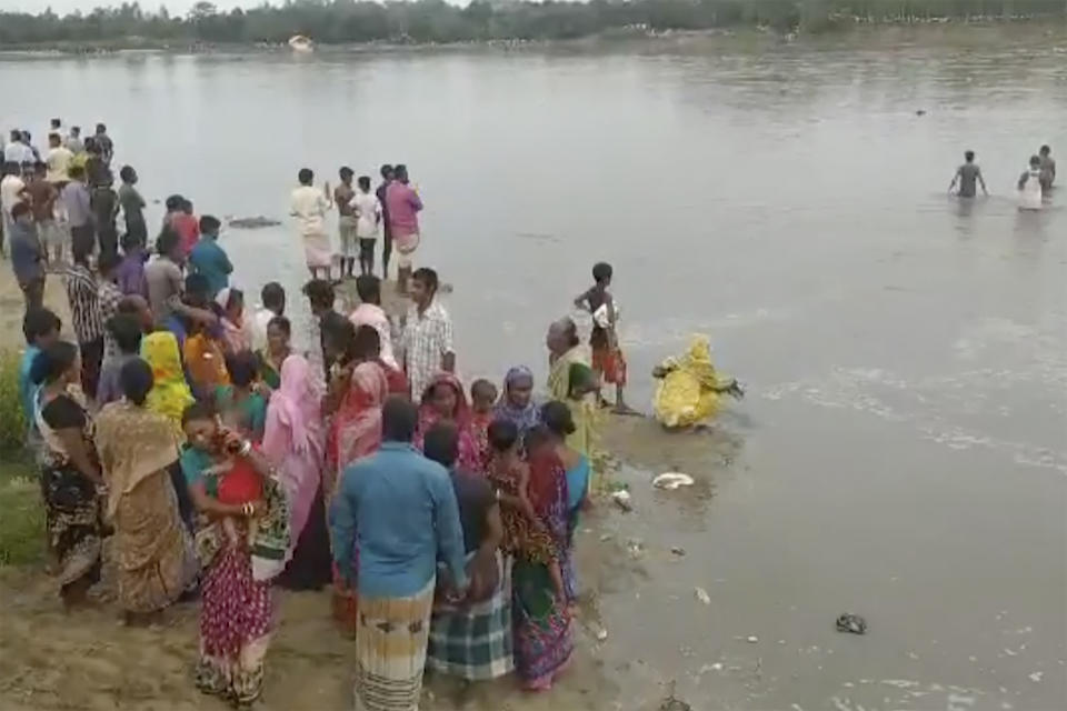 In this image made from a video, people conduct search operation in the River Karatoa where an overcrowded boat overturned, in Panchagarh, Bangladesh Sunday, Sept. 25, 2022. A boat carrying about 100 Hindu pilgrims capsized Sunday in the river in northern Bangladesh, police said. (AP Photo)