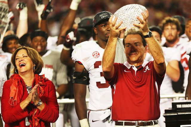 <p>Mike Ehrmann/Getty</p> Nick Saban and Terry Saban celebrate with BCS Coaches' Trophy in January 2013.