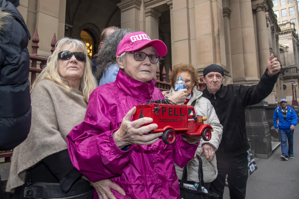 Supporters of abuse victims stand outside the Supreme Court in Melbourne, Australia, Wednesday, Aug. 21, 2019. Australian appeals court by a 2-1 ruling Wednesday upheld convictions against Cardinal George Pell, the most senior Catholic to be found guilty of sexually abusing children. (AP Photo/Andy Brownbill)