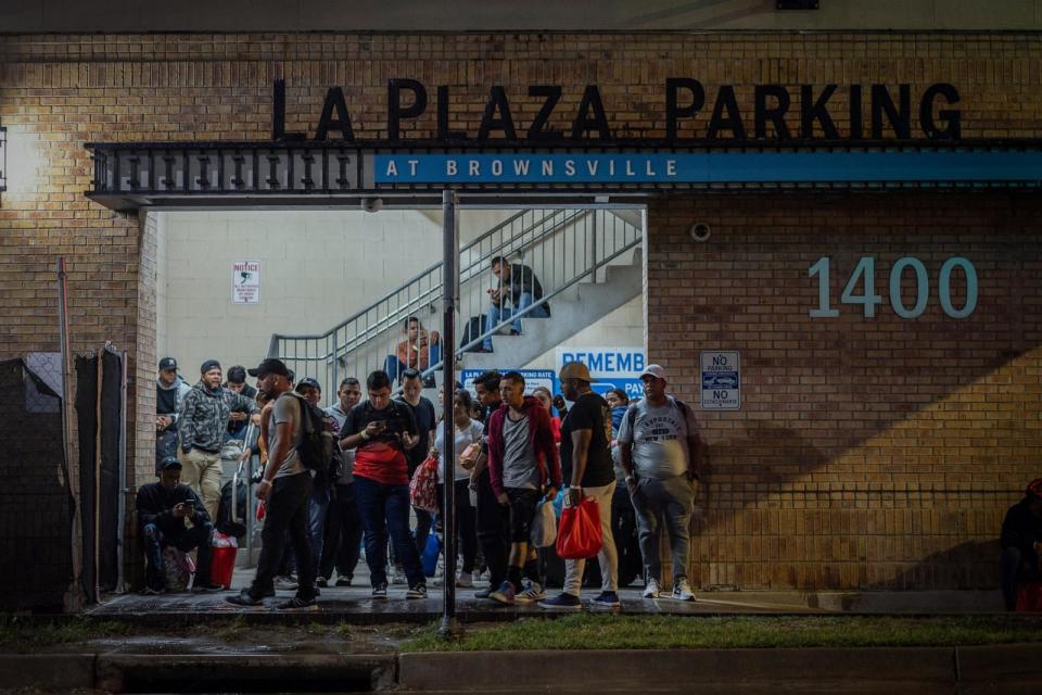 PHOTO: Migrants stand at a processing center as they wait for a bus to Chicago, Oct, 24, 2023, in downtown Brownsville, Texas. (Carlos Barria/Reuters, FILE)