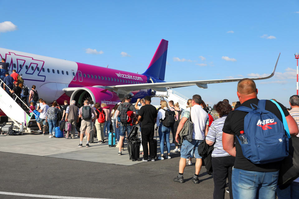 Fluggäste der Airline Wizzair warten auf ihren Einstieg ins Flugzeug. Das Reiseaufkommen in diesem Sommer an den internationalen Flughäfen ist hoch. - Copyright: picture alliance / Micha Korb