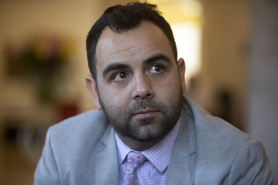 Human Rights Watch researcher Omar Shakir sitsh during an interview in Jerusalem, Sunday, Nov. 24, 2019. Shakir is being deported from Israel over his alleged boycott advocacy says he will remain in his position and continue doing the "important, urgent work" of documenting violations in Israel and the Palestinian territories from abroad. (AP Photo/Sebastian Scheiner)