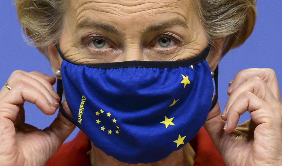 European Commission President Ursula von der Leyen, prepares to take off her protective mask, prior to making a statement regarding the Withdrawal Agreement at EU headquarters in Brussels, Thursday, Oct. 1, 2020. The European Union took legal action against Britain on Thursday over its plans to pass legislation that would breach parts of the legally binding divorce agreement the two sides reached late last year. (Johanna Geron, Pool via AP)