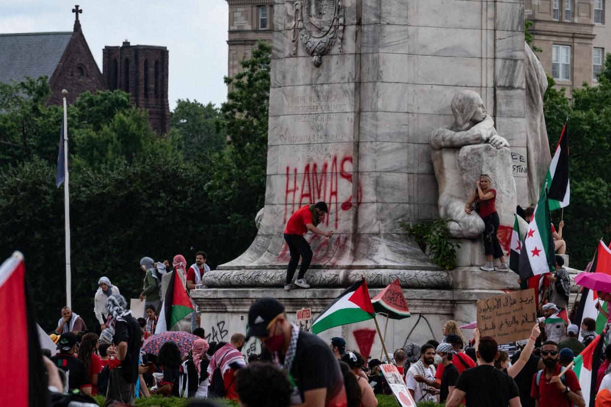 Protester tags "Hamas is Coming" on a Union Station statue