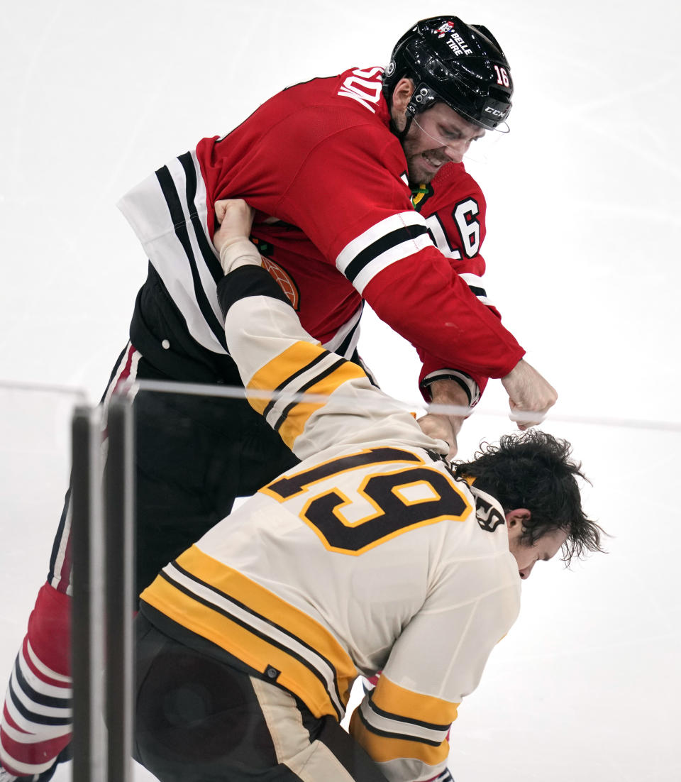 Chicago Blackhawks center Jason Dickinson (16) throws a punch at Boston Bruins center Johnny Beecher (19) during the third period of an NHL hockey game, Wednesday, Oct. 11, 2023, in Boston. (AP Photo/Charles Krupa)