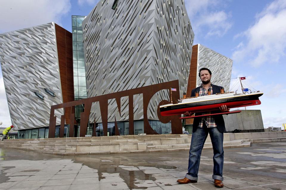 FILE   In this Wednesday, March 7, 2012 file photo Justin Lowry holds his model of the Titanic which will be one of many object on display in the the new 100 million pound Titanic Belfast visitor center, Belfast, Northern Ireland.  Celebrating the ship and the people who built her is the aim of Titanic Belfast, a shiny new "visitor experience" _ don't call it a museum _ whose four prow-like wings jut jauntily skyward beside the River Lagan on the site of the old Harland and Wolff shipyard. Titanic, the world's largest, most luxurious ocean liner, left this spot on April 2, 1912 on its maiden voyage from England to New York. Twelve days later, it stuck an iceberg off the coast of Newfoundland and sank in the early hours of April 15.  More than 1,500 of the 2,200 people on board died.   (AP Photo/Peter Morrison)