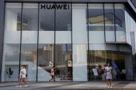 People walk past a Huawei store in Beijing