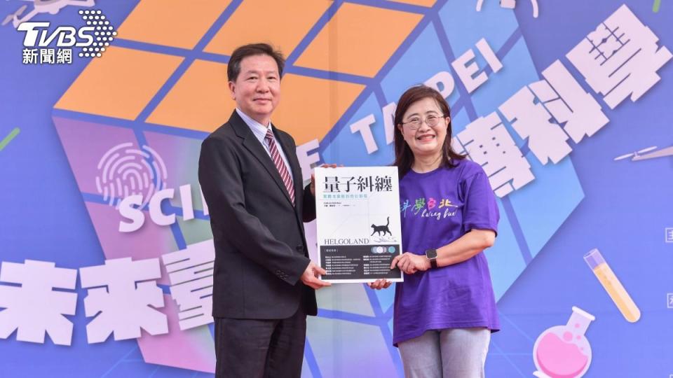 陳界山（左）也代表臺師大致贈科普書籍《量子糾纏 黑爾戈蘭島的奇幻旅程》給臺北市副市長林奕華（右）。（圖／TVBS）