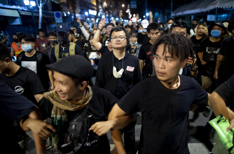 Pro-democracy activist and human rights lawyer Arnon Nampha, center, and student leaders walk to a police station in anticipation of arrest after a protest rally at Democracy Monument in Bangkok, Thailand, Sunday, Aug, 16, 2020. Protesters have stepped up pressure on the government demanding to dissolve the parliament, hold new elections, amend the constitution and end intimidation of the government's opponents. (AP Photo/Gemunu Amarasinghe)