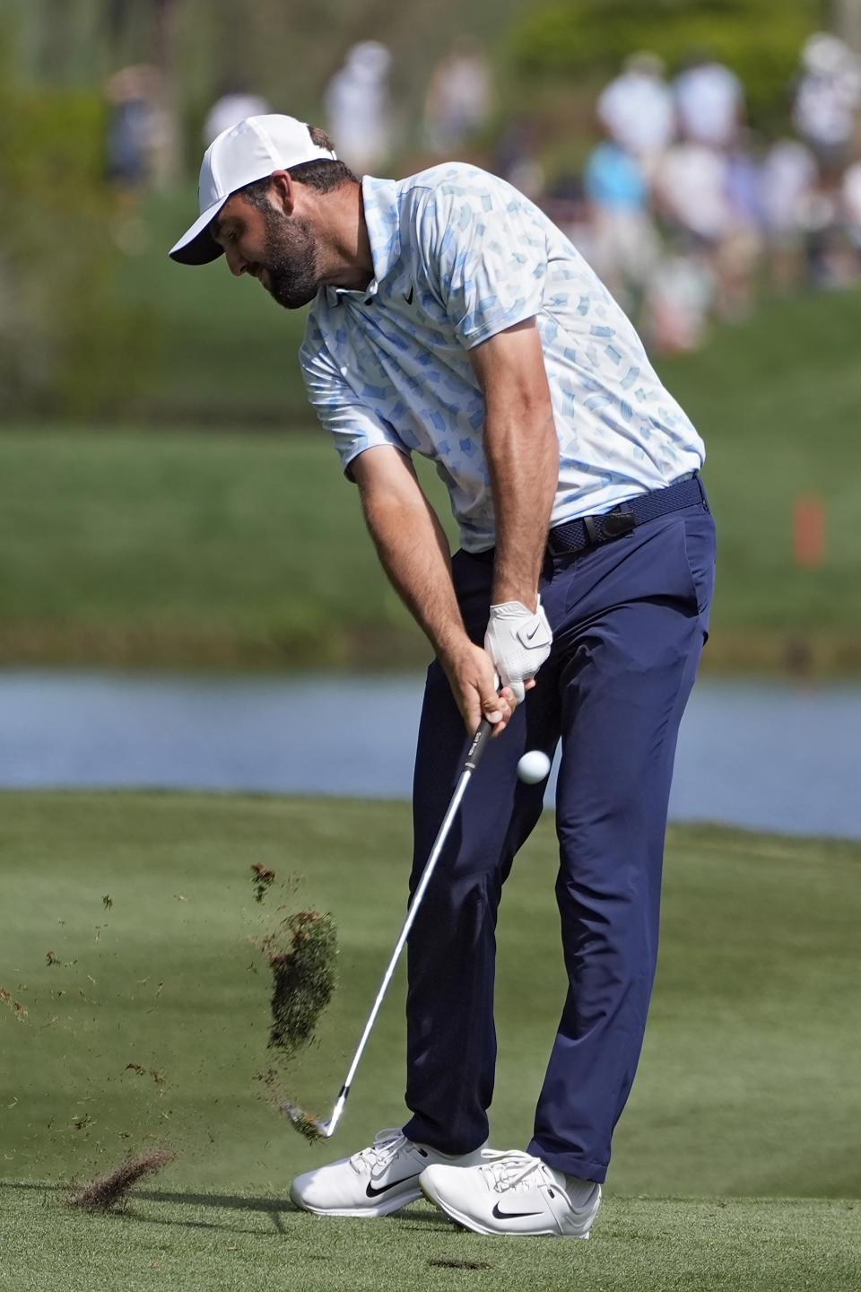 Scottie Scheffler takes a divot as he hits from the sixth fairway during the first round of The Players Championship golf tournament Thursday, March 14, 2024, in Ponte Vedra Beach, Fla. (AP Photo/Marta Lavandier)