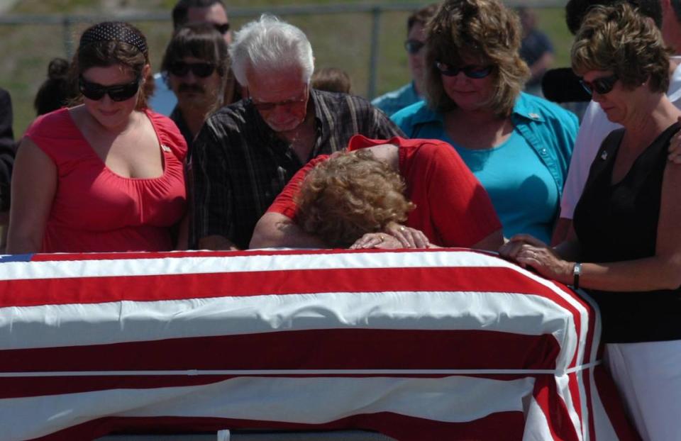 Family members grieve as they stand at the flag draped casket of Army Pfc. Christopher North , after its arrival at the Sarasota Bradenton International Airport on Friday, April 27, 2007.