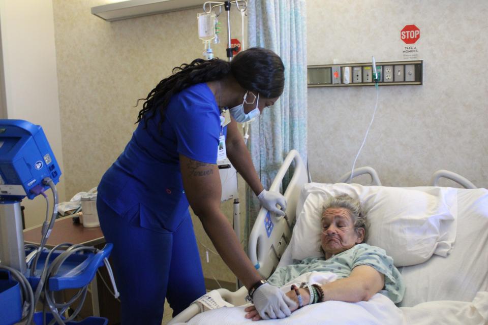 A certified nursing assistant takes a patient's vital signs.