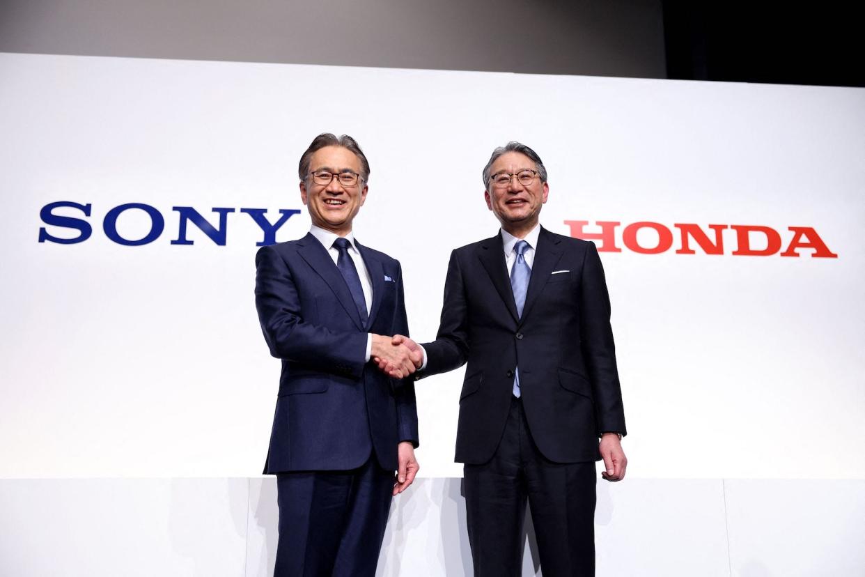 Sony president and CEO Kenichiro Yoshida (L) and Honda president Toshihiro Mibe shake hands after announcing the partnership in Marc