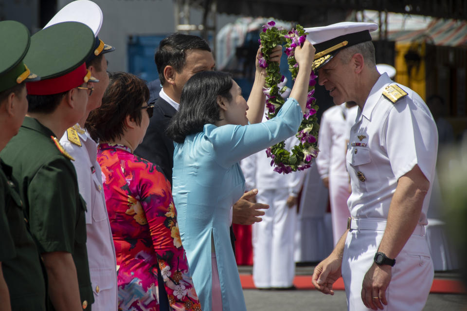 In this photo provided by U.S. Navy, Rear Adm. Pat Hannifin, right, receives a wreath during a welcome ceremony after the USS Ronald Reagan (CVN 76), anchored into Da Nang, Vietnam, for a routine port visit, Sunday, June 25, 2023. (Mass Communication Specialist 2nd Class Keyly Santizo/U.S. Navy via AP)