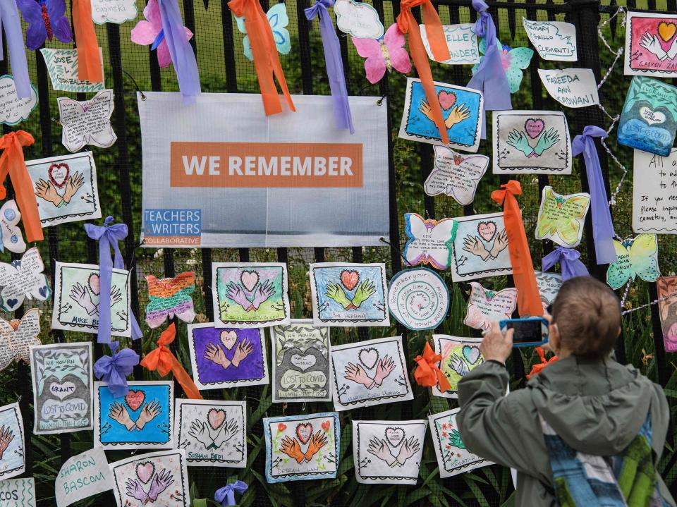 A person takes a picture at the “Naming the Lost Memorials” installation to remember the lives lost due to the coronavirus pandemic at The Green-Wood Cemetery on 11 June 2021 in New York City (AFP via Getty Images)