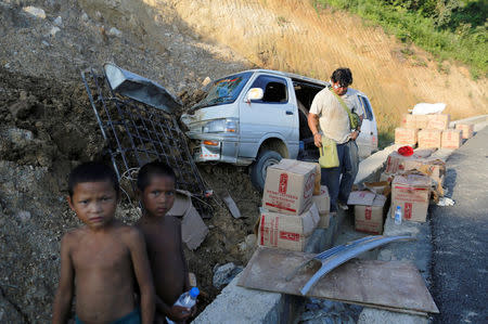 A driver collects his belongings after a car crash outside Panghsang capital city of ethnic Wa territory in northeast Myanmar October 5, 2016. REUTERS/Soe Zeya Tun