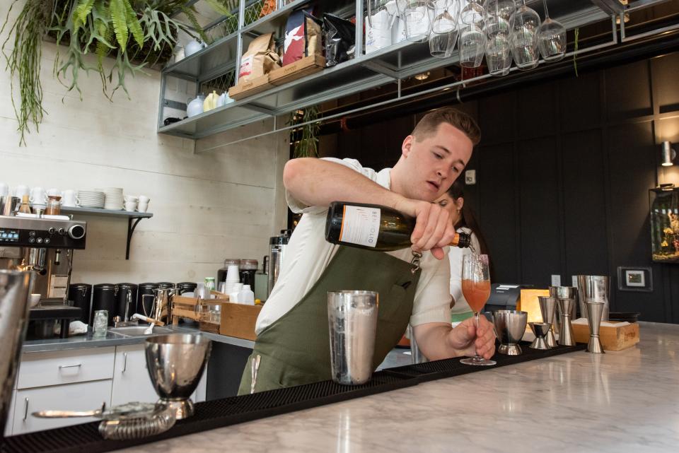 Andrew DeRosier, a bartender at Terrain Cafe, mixes a guava elderflower mimosa during a preview event on Wednesday, June 28, 2023.