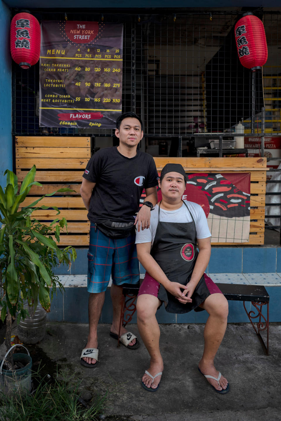 Orias (right) and his childhood friend Jonathan Artates at their Takoyaki shop in San Mateo, Rizal, in the outskirts of Manila, Philippines, on July 19, 2022. It was Artates who introduce Orias to the Axie Infinity game. He has also quit the game after his account was hacked.<span class="copyright">Ezra Acayan for TIME</span>