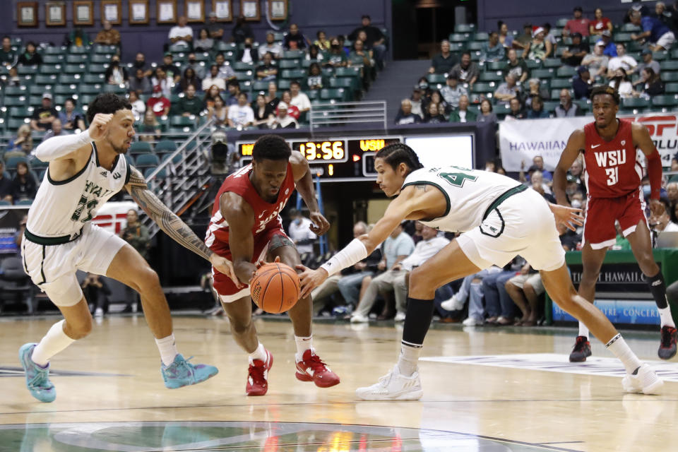 Washington State guard TJ Bamba, center, reaches for the ball between Hawaii guard Samuta Avea (32) and forward Kamaka Hepa (44) during the first half of an NCAA college basketball game Friday, Dec. 23, 2022, in Honolulu. (AP Photo/Marco Garcia)