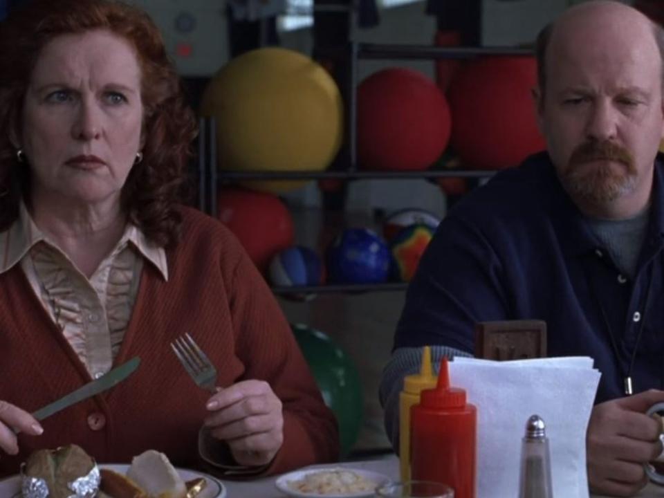 Two teachers eating in the school cafeteria.