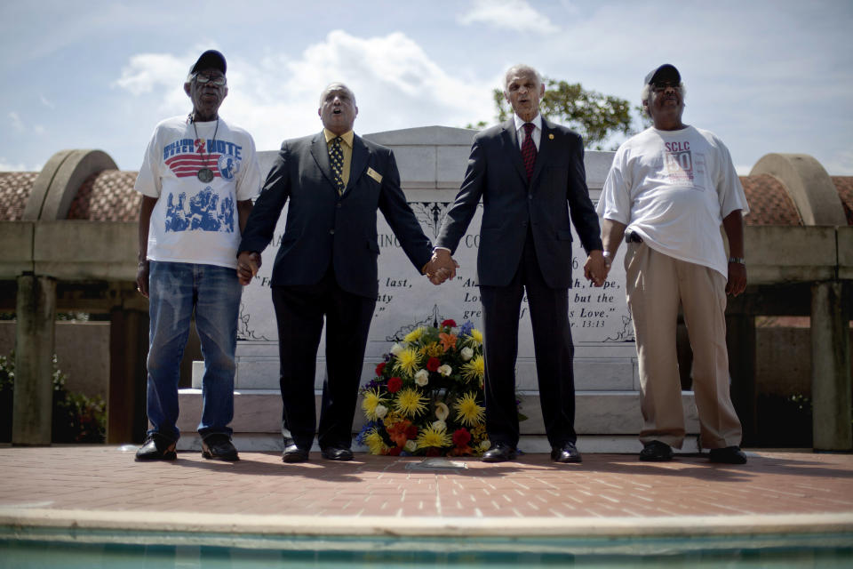 FILE - In this April 4, 2012, file photo, civil rights activists and Southern Christian Leadership Conference members from left, Ralph Worrell, Dr. Bernard Lafayette Jr., C.T. Vivian and Frederick Moore, join hands and sing "We Shall Overcome" at the Atlanta gravesite of the Rev. Martin Luther King Jr., marking the 44th anniversary of his assassination. This Sunday, March 7, 2021, marks the 56th anniversary of the Selma marches and "Bloody Sunday," when more than 500 demonstrators gathered on March 7, 1965, to demand the right to vote and cross Selma's Edmund Pettus Bridge. (AP Photo/David Goldman, File)
