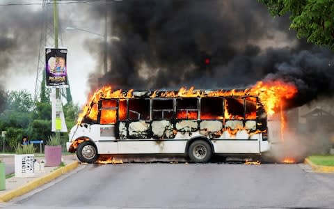 A bus burns following the shootout between armed gunmen in Mexican security forces in Culiacan, Mexico.  - Credit: Jesus Bustamante/Reuters