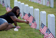 <p>Takima Roach places a flag at the grave marker of her husband, Navy Petty Officer 1st Class Clarence J. Roach, who died in August 2015, at the Jacksonville National Cemetery, in Jacksonville Fla., on Saturday May 28, 2016. (Bob Mack /The Florida Times-Union via AP) </p>