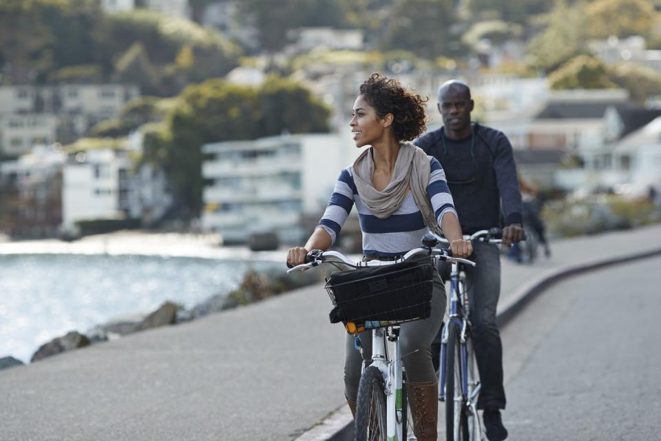 4th of july activities man and woman riding bikes along sidewalk and water