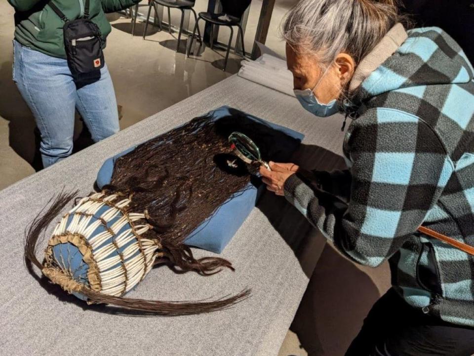 Petra A’Huille, Maiyoo Keyoh hereditary chief, examines the headdress that belonged to her great-great-grandfather, George A’Huille. The headdress is going on display near its home territory in northern B.C. after about 140 years at the Royal Ontario Museum. (Maiyoo Keyoh - image credit)