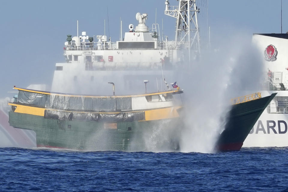 Philippine resupply vessel Unaizah May 4, foreground, is hit by two Chinese coast guard water canons as they tried to enter the Second Thomas Shoal, locally known as Ayungin Shoal, in the disputed South China Sea Tuesday, March 5, 2024. Chinese and Philippine coast guard vessels collided in the disputed South China Sea and four Filipino crew members were injured in high-seas confrontations Tuesday as Southeast Asian leaders gathered for a summit that was expected to touch on Beijing's aggression at sea. (AP Photo/Aaron Favila)