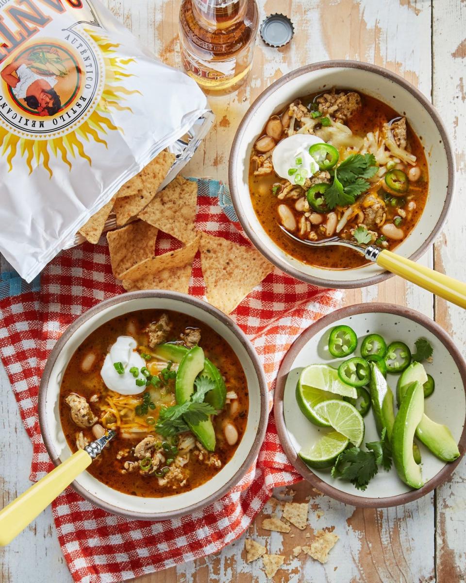 classic white chicken chili in bowls with sour cream cilantro and sliced avocado on top