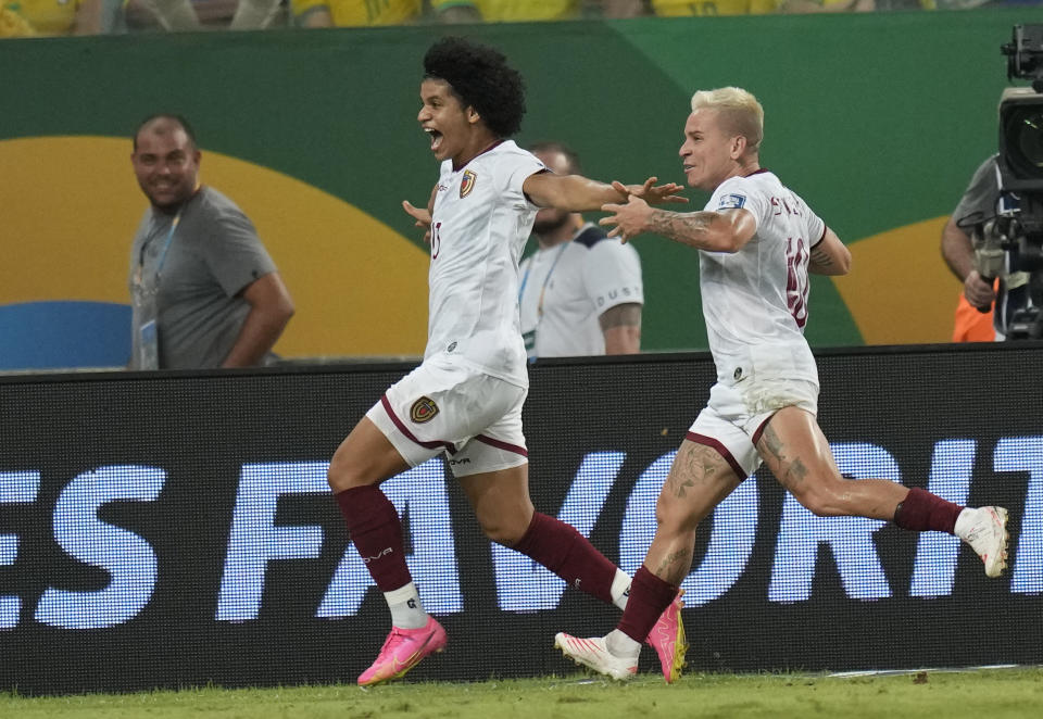 Venezuela's Eduardo Bello, left, celebrates scoring his side's opening goal against Brazil during a qualifying soccer match for the FIFA World Cup 2026 at Arena Pantanal stadium in Cuiaba, Brazil, Thursday, Oct.12, 2023. (AP Photo/Andre Penner)