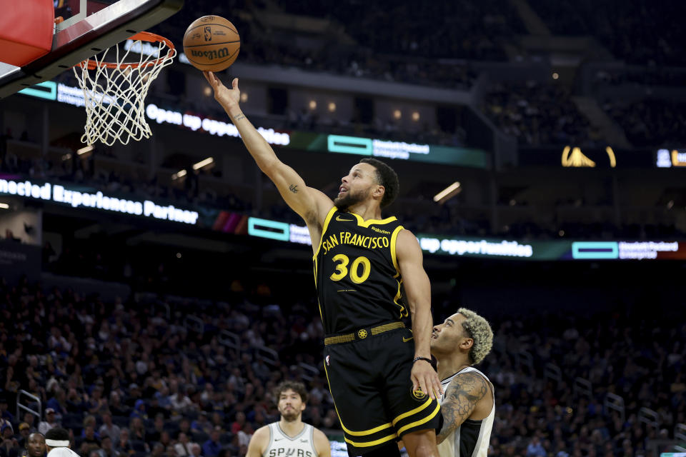 Golden State Warriors guard Stephen Curry (30) shoots against San Antonio Spurs forward Jeremy Sochan, right, during the first half of an NBA basketball In-Season Tournament game in San Francisco, Friday, Nov. 24, 2023. (AP Photo/Jed Jacobsohn)