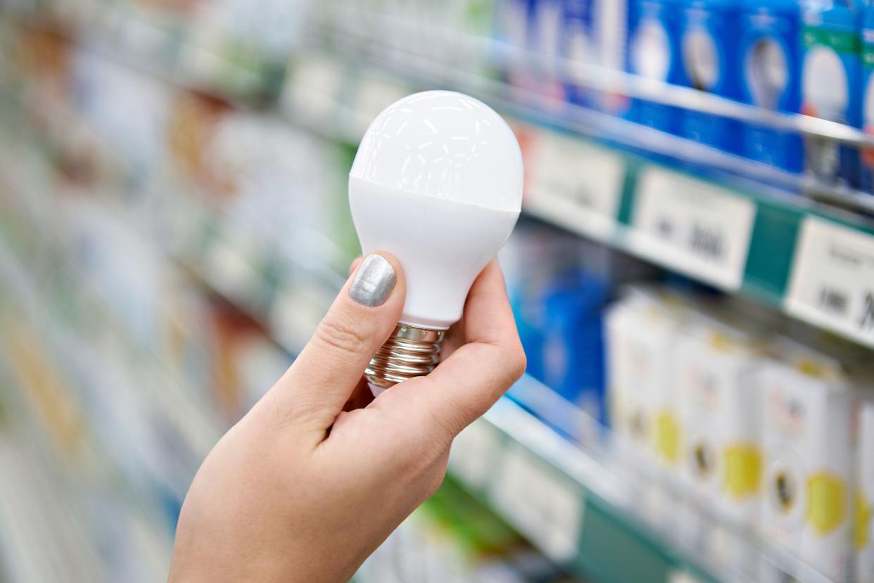 energy saving LED lamp in hands of buyer at store