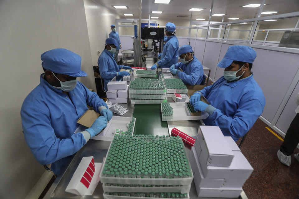 FILE- In this Jan. 21, 2021, file photo, employees pack boxes containing vials of Covishield, a version of the AstraZeneca vaccine at the Serum Institute of India in Pune, India. India, the world's largest vaccine producer, says it will resume exports and donations of surplus coronavirus vaccines in October after halting them during a devastating surge in domestic infections in April. (AP Photo/Rafiq Maqbool, File)