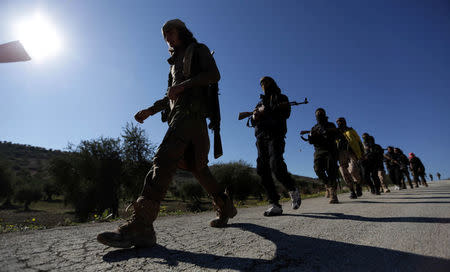 Turkish-backed Free Syrian Army fighters walk together after advancing north of Afrin, Syria March 17, 2018. REUTERS/Khalil Ashawi